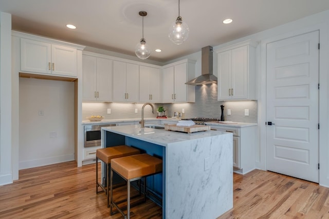 808A 45th Ave N, Nashville, TN 37209 - kitchen with wall chimney range hood, white cabinets, a sink, and light wood-style floors