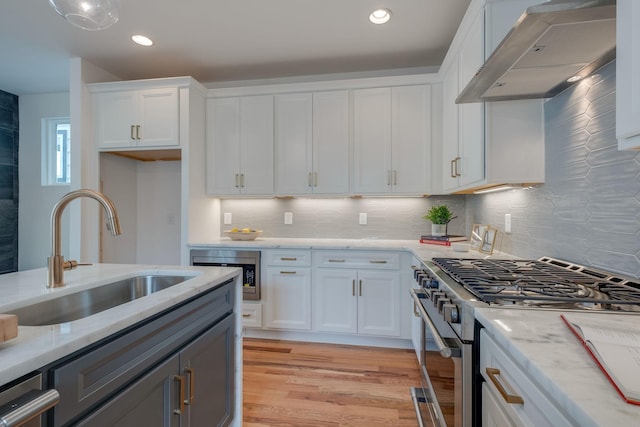 808A 45th Ave N, Nashville, TN 37209 - kitchen featuring light wood-style flooring, stainless steel range with gas cooktop, white cabinetry, a sink, and extractor fan