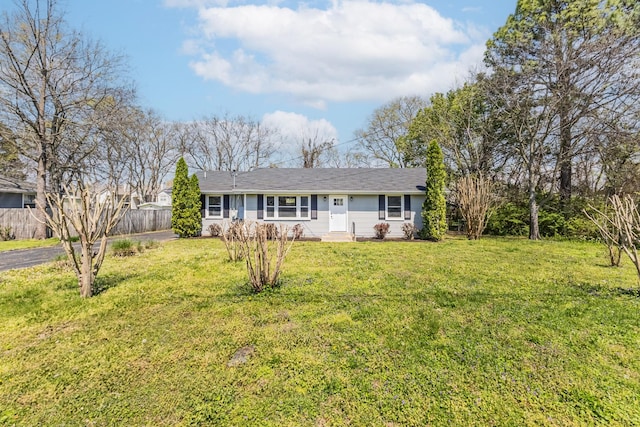 single story home featuring entry steps, a front yard, and fence