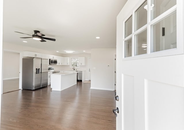 unfurnished living room featuring dark wood-style floors, baseboards, a ceiling fan, and recessed lighting