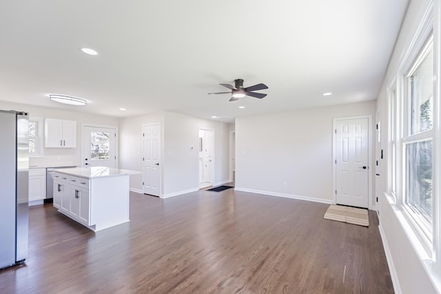 unfurnished living room featuring ceiling fan, recessed lighting, baseboards, and dark wood finished floors
