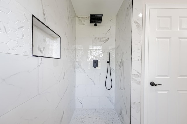bathroom featuring a marble finish shower