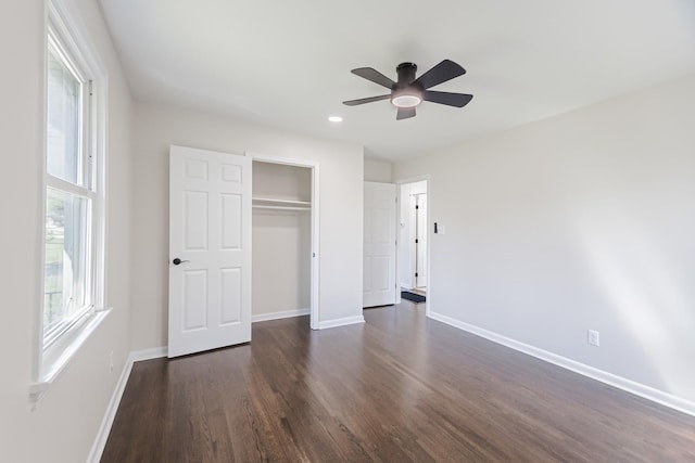 unfurnished bedroom with a closet, baseboards, ceiling fan, and dark wood finished floors