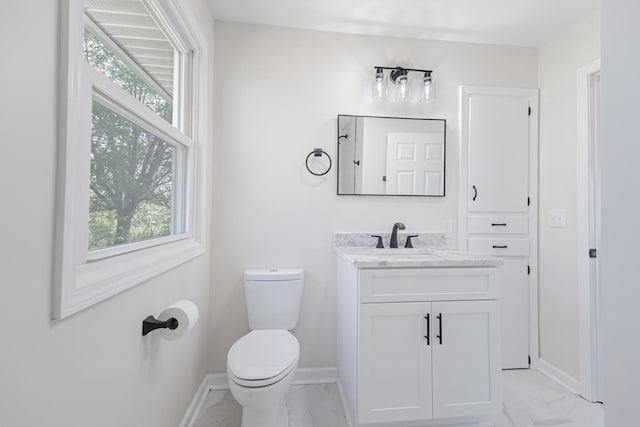 half bath featuring baseboards, marble finish floor, and a healthy amount of sunlight