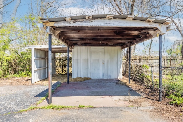view of outdoor structure featuring a detached carport and fence