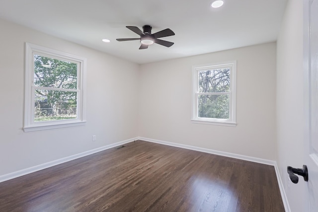 unfurnished room with a ceiling fan, baseboards, dark wood-style floors, and plenty of natural light