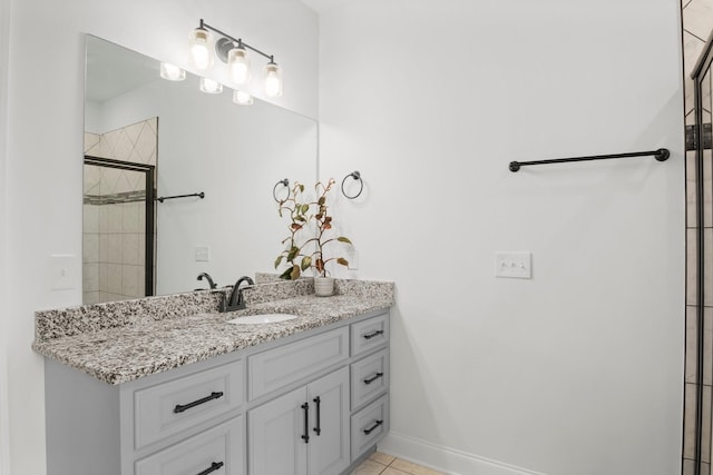 bathroom featuring baseboards, a tile shower, tile patterned flooring, and vanity