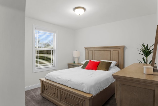 bedroom with baseboards and dark carpet
