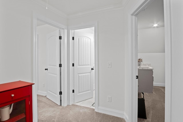 hallway featuring carpet floors, ornamental molding, and baseboards