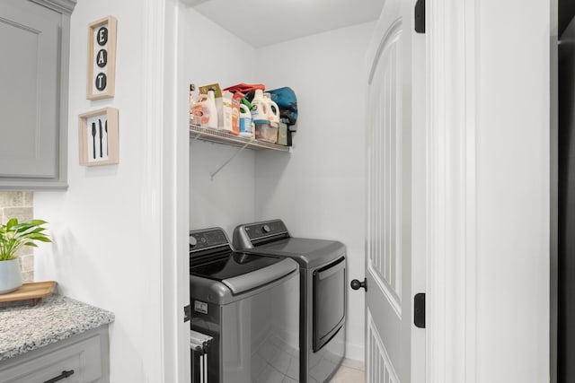 washroom with light tile patterned flooring, independent washer and dryer, and laundry area