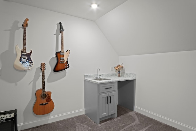 bathroom featuring baseboards, lofted ceiling, and vanity