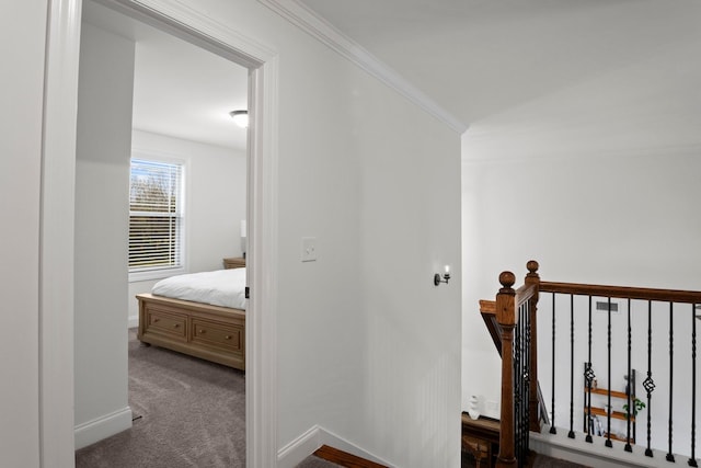 hallway with baseboards, carpet flooring, an upstairs landing, and ornamental molding