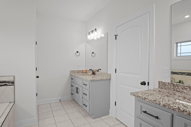 bathroom featuring tile patterned flooring, a sink, two vanities, and baseboards