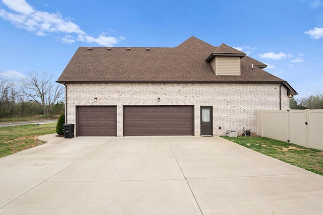 view of home's exterior with fence, an attached garage, brick siding, roof with shingles, and driveway