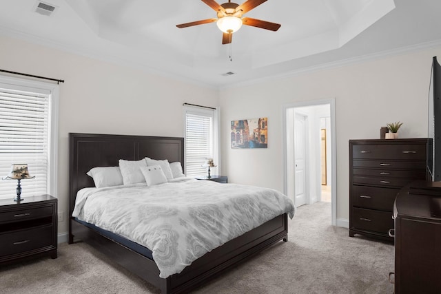 bedroom featuring light carpet, baseboards, visible vents, and a raised ceiling