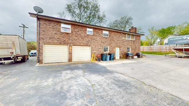 120 Gatone Dr, Hendersonville, TN 37075 - rear view of house with an attached garage, a chimney, fence, brick siding, and driveway