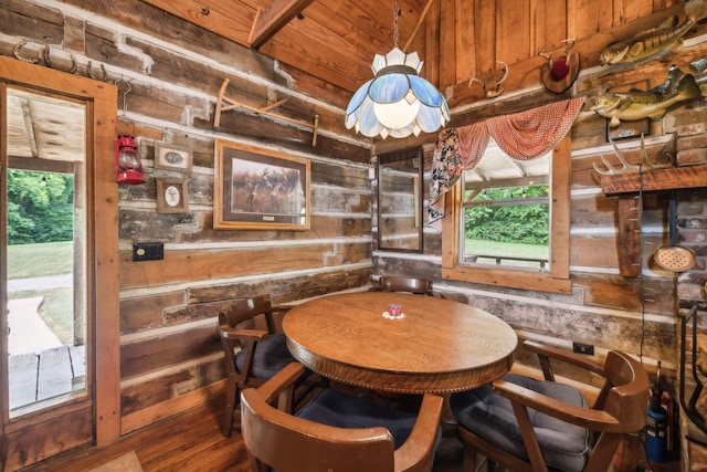 dining area featuring wood walls and wood finished floors