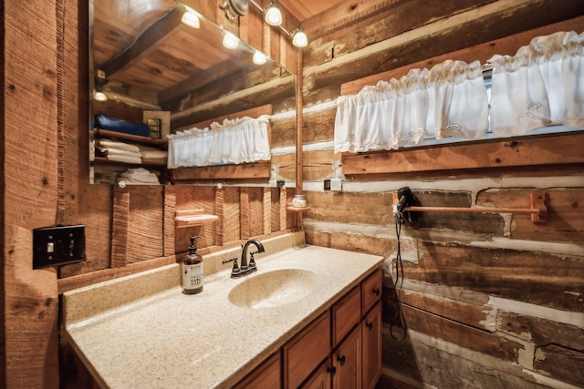 bathroom with wood ceiling, vanity, and wood walls