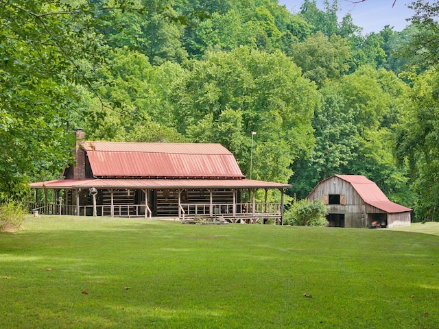 exterior space featuring metal roof, a chimney, a gambrel roof, a barn, and an outdoor structure