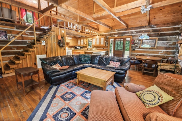 living area featuring visible vents, wooden walls, stairway, beam ceiling, and wood-type flooring