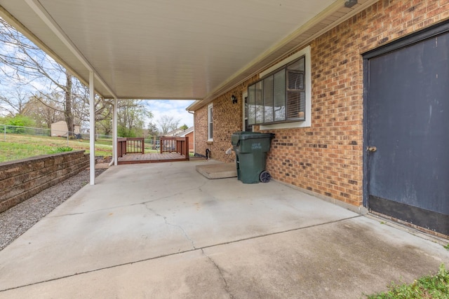 view of patio / terrace featuring a carport, fence, and a wooden deck