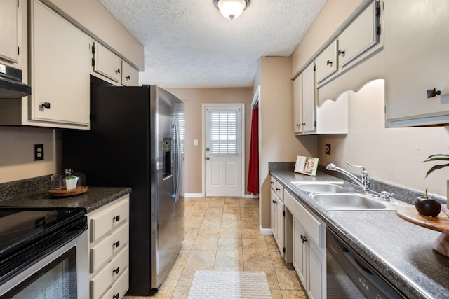 kitchen featuring dark countertops, under cabinet range hood, a sink, and stainless steel appliances