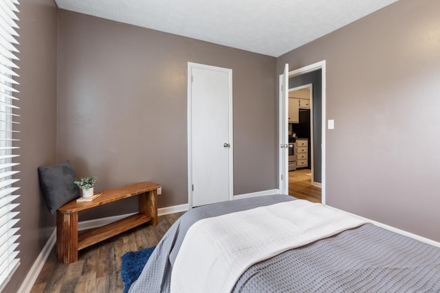 bedroom with baseboards, a textured ceiling, and wood finished floors