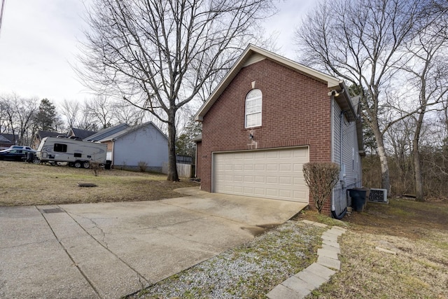 view of side of property featuring brick siding, a garage, and concrete driveway