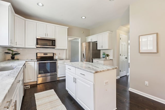 kitchen with dark wood finished floors, white cabinetry, and stainless steel appliances
