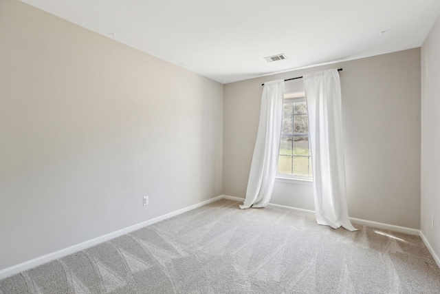 empty room with baseboards, visible vents, and carpet