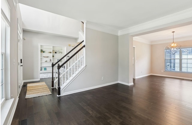 entrance foyer featuring dark wood-style flooring, visible vents, ornamental molding, stairway, and a notable chandelier