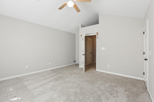 unfurnished bedroom featuring baseboards, vaulted ceiling, light colored carpet, and a ceiling fan