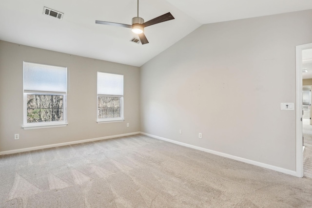carpeted empty room with baseboards, visible vents, ceiling fan, and vaulted ceiling