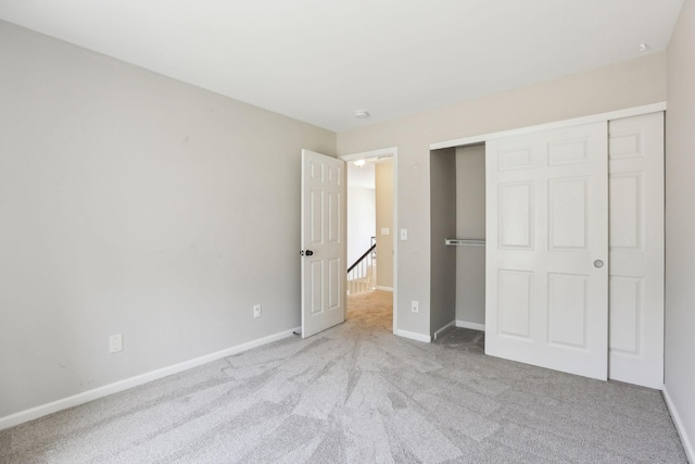 unfurnished bedroom featuring carpet flooring, baseboards, and a closet