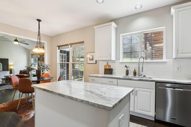 kitchen with a sink, a kitchen island, stainless steel dishwasher, plenty of natural light, and ceiling fan