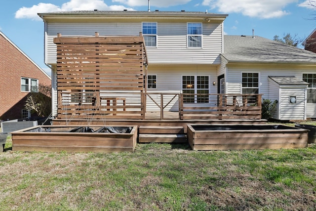 rear view of property featuring roof with shingles, a deck, and a yard