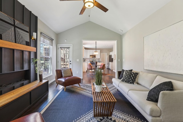 living room with wood finished floors, baseboards, vaulted ceiling, and ceiling fan