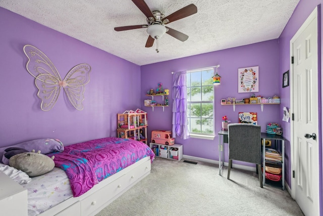 carpeted bedroom featuring baseboards, a textured ceiling, and a ceiling fan