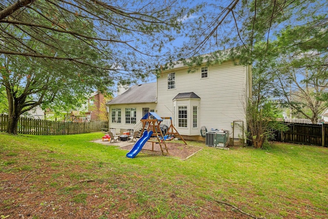 rear view of house featuring a patio, a fenced backyard, a playground, and a lawn