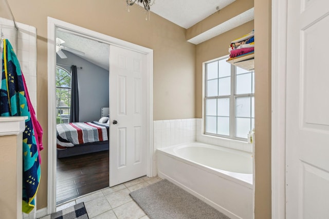 full bath featuring a textured ceiling, a garden tub, ensuite bathroom, and tile patterned flooring
