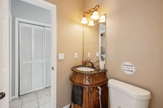 half bathroom featuring toilet, tile patterned flooring, and vanity