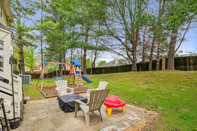 view of yard with a fenced backyard, a playground, a patio, and central air condition unit