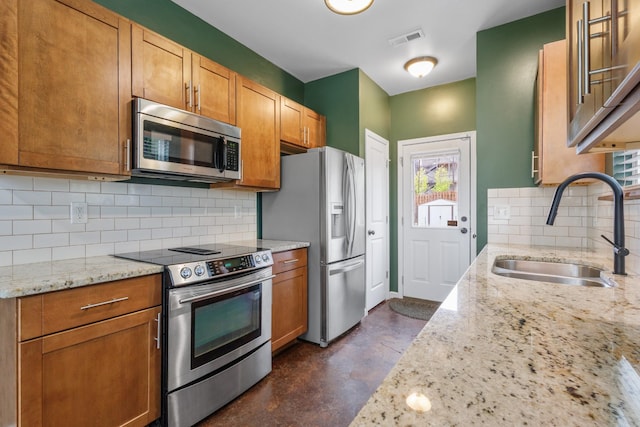 kitchen with visible vents, light stone countertops, stainless steel appliances, a sink, and concrete flooring
