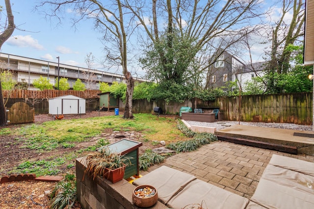 view of yard featuring an outdoor structure, a fenced backyard, a storage unit, and a patio area