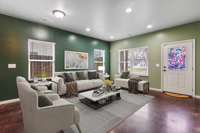 living room featuring baseboards, finished concrete flooring, visible vents, and recessed lighting