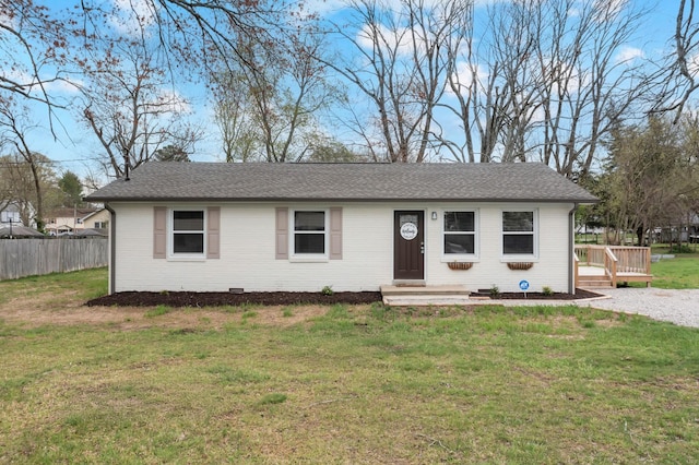 ranch-style house with a shingled roof, a front yard, a wooden deck, and fence
