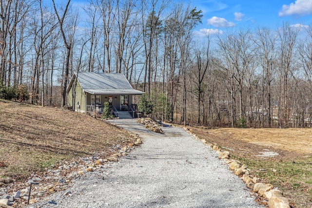 exterior space featuring driveway and a forest view