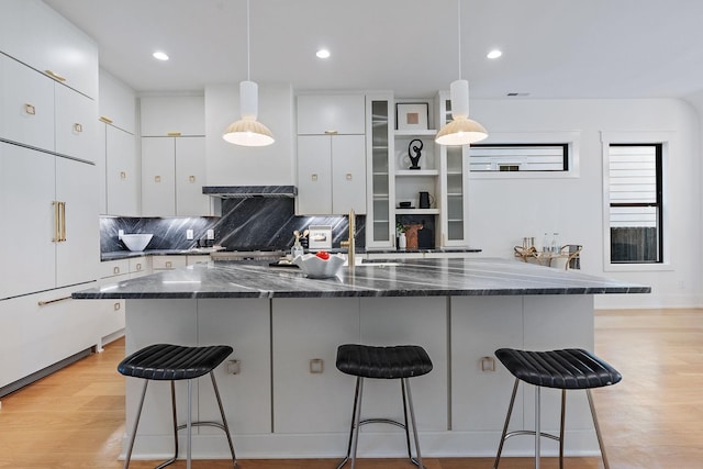 843B Dewees Ave, Nashville, TN 37204 - kitchen featuring white cabinetry, a breakfast bar area, backsplash, and light wood finished floors
