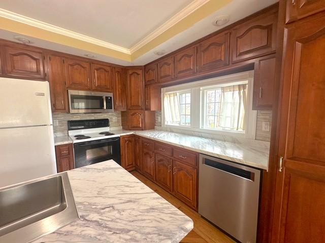 522 Norris Hancock, Big Rock, TN 37023 - kitchen with tasteful backsplash, brown cabinets, light countertops, and stainless steel appliances