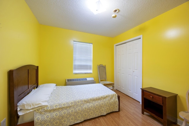 328 Cumberland St W, Cowan, TN 37318 - bedroom featuring wood finished floors, a textured ceiling, a closet, and a wall mounted AC